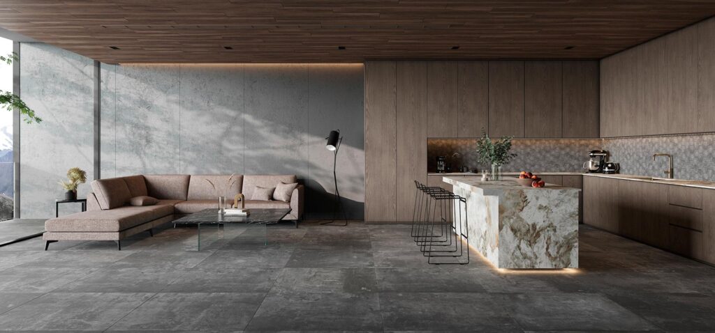 Suelo de porcelánico gris oscuro de gran formato en un espacio abierto de lujo que conecta el salón con una cocina de diseño con isla de mármol y mobiliario de madera.
